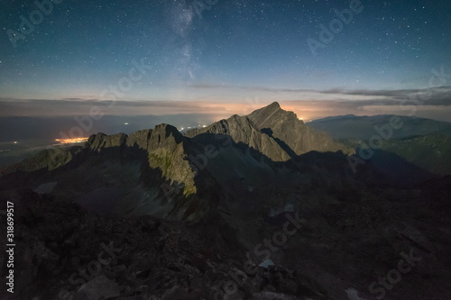 High mountains illuminate the moon when sleeping under the night sky, on which the Milky Way