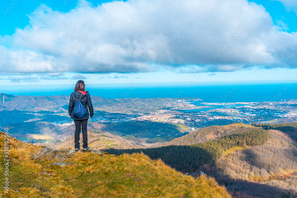 Naklejka premium A young mountaineer looking at the village of Fuenterrabia from the mountain of Aiako Harria, Oiartzun. Basque Country