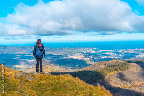 A young mountaineer looking at the village of Fuenterrabia from the mountain of Aiako Harria, Oiartzun. Basque Country