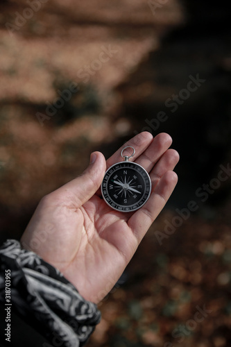 The compass in my hand is in the background FOREST, Compass, navigational compass, travel compass, lost compass,
