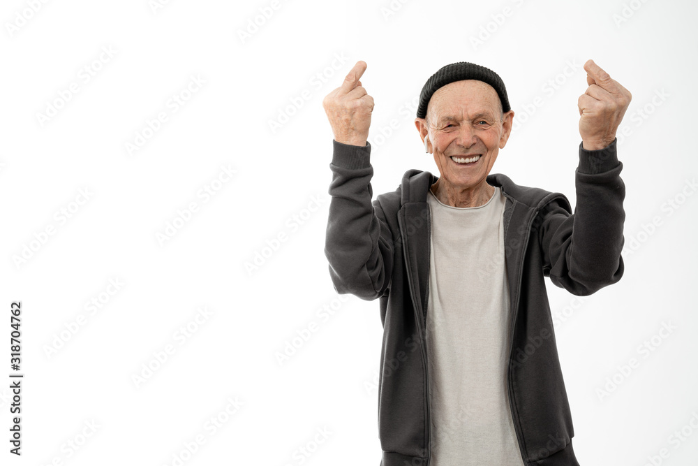 Happy smiling old man in black hat , white headphones and hoodie, stylish senior showing middle finger with a missing phalanx doing fuck you bad expression, provocation and rude attitude, isolated