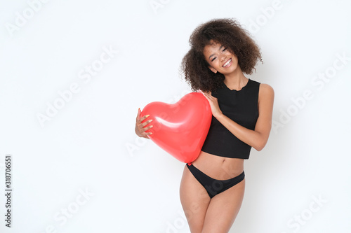 Pretty, young and full of energy afro-amercian model with heart shaped balloon. © forma82