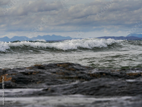 Atlantic ocean, Wave crashing, Galway bay, Ireland. Mountains silhouette in the background.