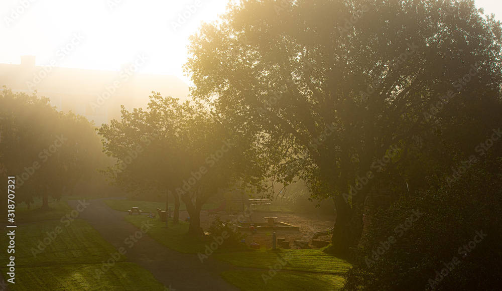 The sun shining throug dense morning fog over a playground. The sun shining throug dense morning fog over a playground.
