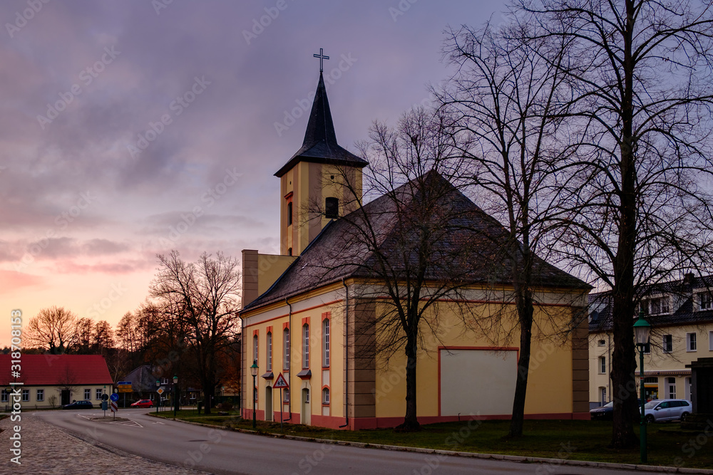 Sonnenuntergang hinter der denkmalgeschützten Dorfkirche Märkisch Buchholz, Blick von Osten