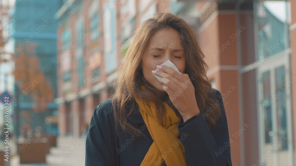 Bad look young woman stand sneezing coughs feel sick at outdoor fever cold allergy city beautiful disease female nose lady runny tissue air pollution adult illness district slow motion