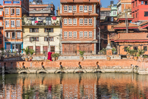 Colorful houses reflecting in the pond at the Pimbahal Pokhari Krishna temple in Patan, Nepal