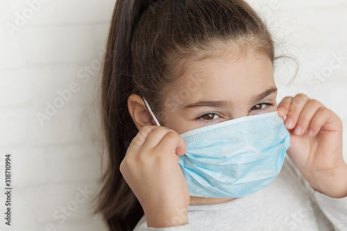 Child in a sterile medical mask. Sick little girl. Epidemic of flu. Virus, coronavirus.