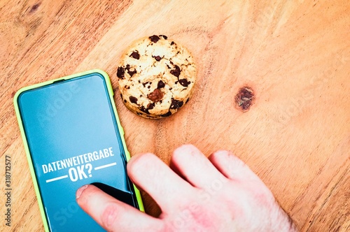 Cookies mit einem Tablet zur Verdeutlichung von Cookie Bannern für Websites mit auf deutsch Datenweitergabe ok? in Englisch Data transfer ok? photo