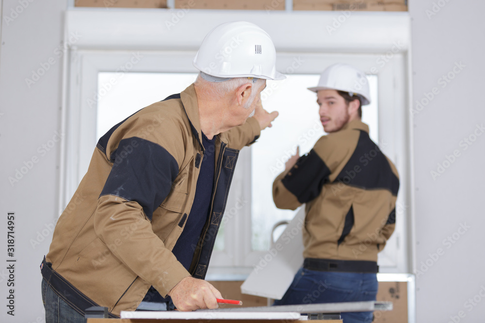 senior builder and young builder discussing a new project senior builder and young builder discussing a new project