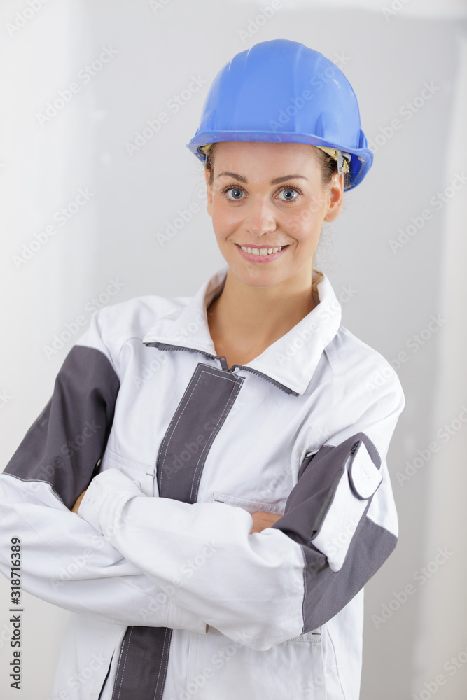 smiling woman wearing builder helmet standing with crossed arms smiling woman wearing builder helmet standing with crossed arms