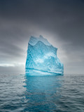 alone iceberg under clouds