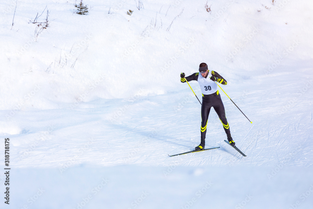 A man cross-country skiing on trail. Guy with modern ski equipment and race number - obrazy, fototapety, plakaty 
