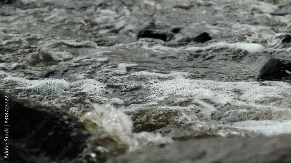 Small river close-up. Powerful water stream among boulders in mountain creek with rapids. Small river close-up. Powerful water stream among boulders in mountain creek with rapids.