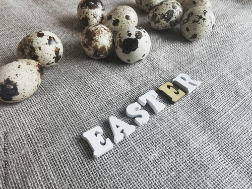 Concept of Easter. Beans eggs in hay on a wooden plate. 