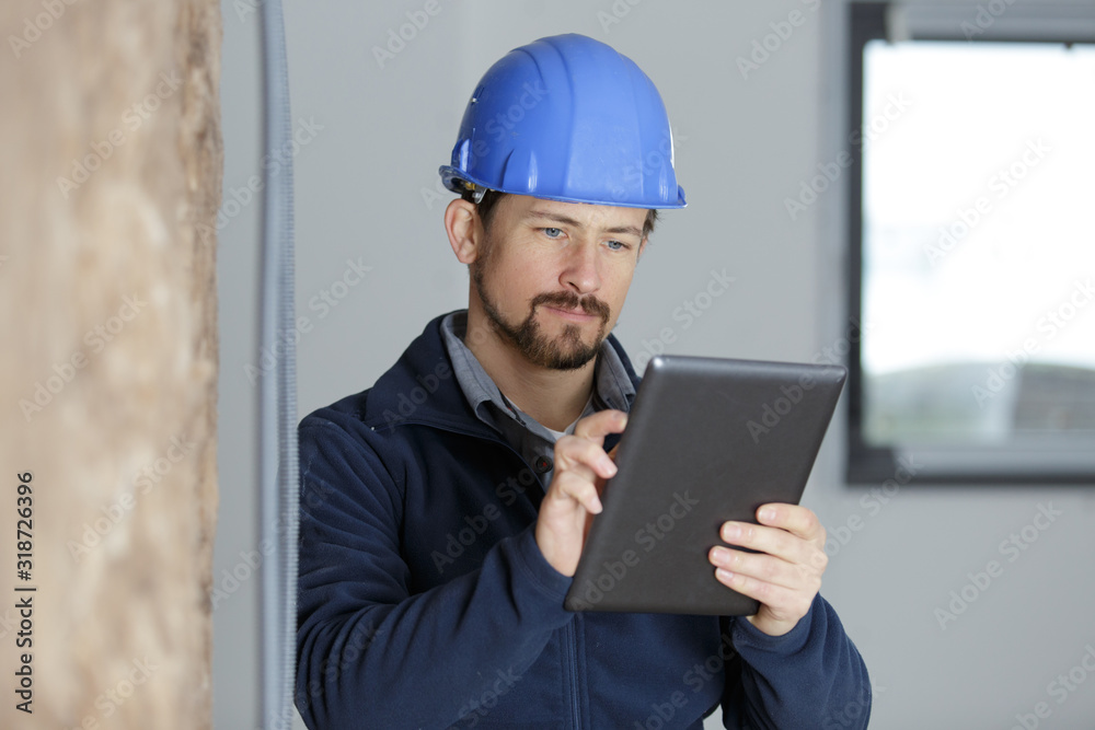 man builde uses a tablet in site man builde uses a tablet in site