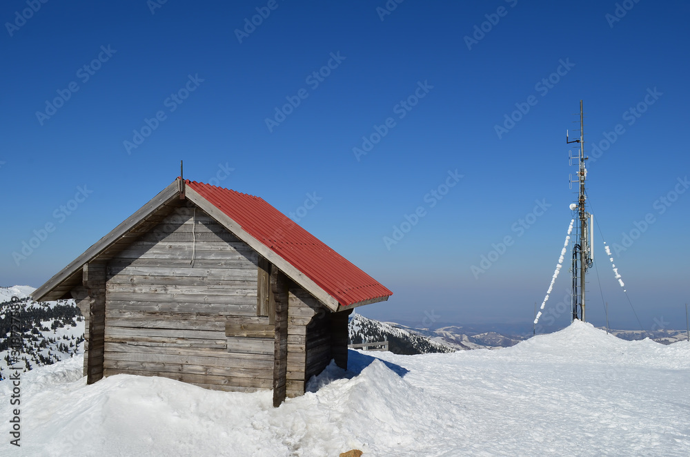Small log house and antenna on the top of mountain