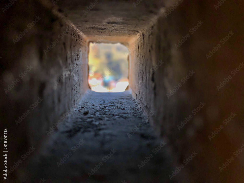 Obraz premium Look through the inside of rectangle brick hole in different perspective and affinities , sunlight is seeping in