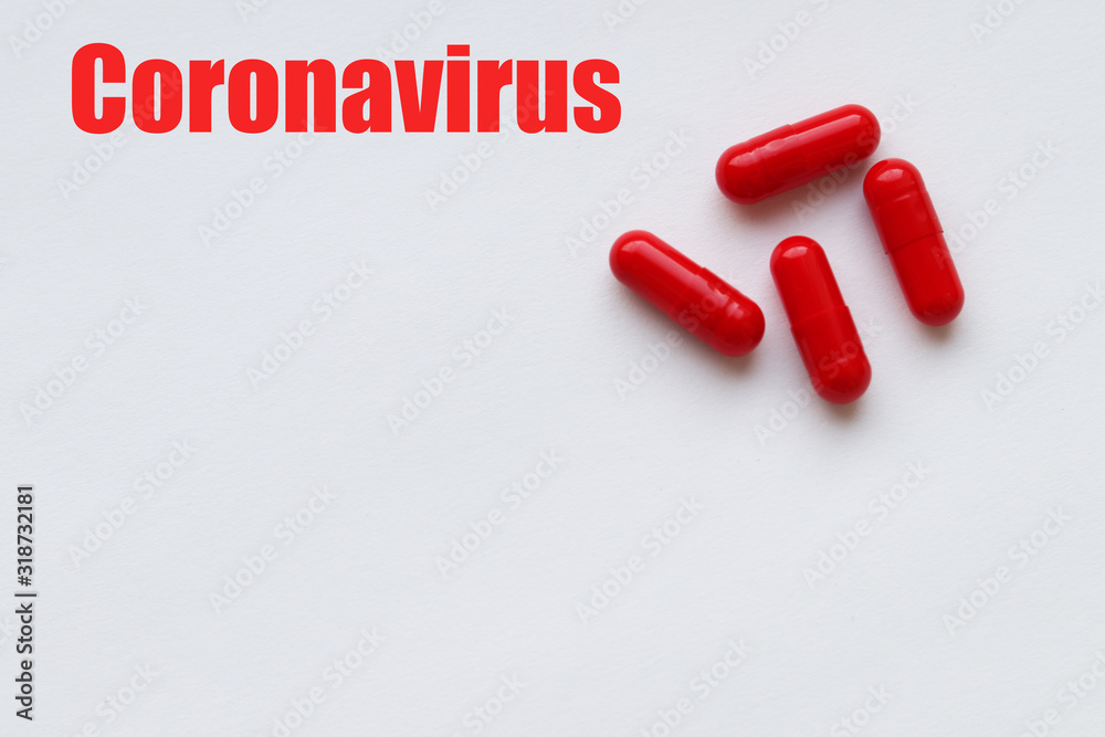 Four red capsules on a white background and the inscription: Coronavirus in red font. Copy space. Selective focus on the capsules. Four red capsules on a white background and the inscription: Coronavirus in red font. Copy space. Selective focus on the capsules.