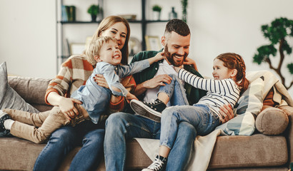 happy family mother father and kids at home on couch .