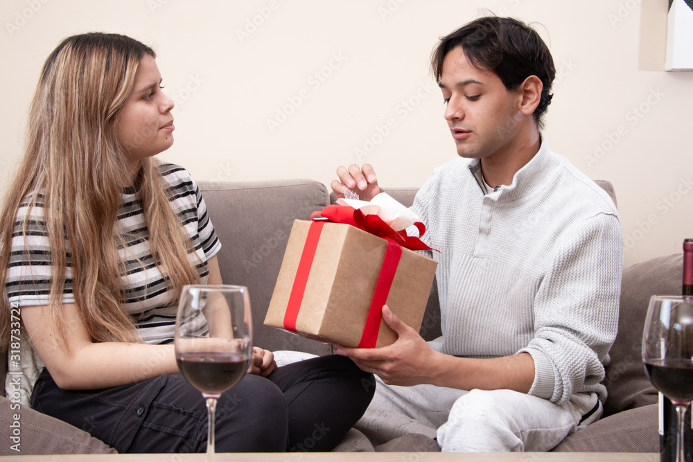 Cute young latin couple exchanging gift for valentines day Cute young latin couple exchanging gift for valentines day