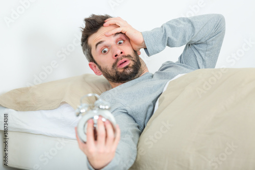 Fotografija young handsome man waking up too late