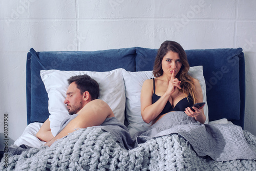 Fotografie Girlfriend secretly chatting with others while he sleeps