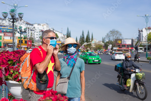 Photography Caucasian woman and man wearing sanitary mask outdoors in Da Lat city centre Vietnam