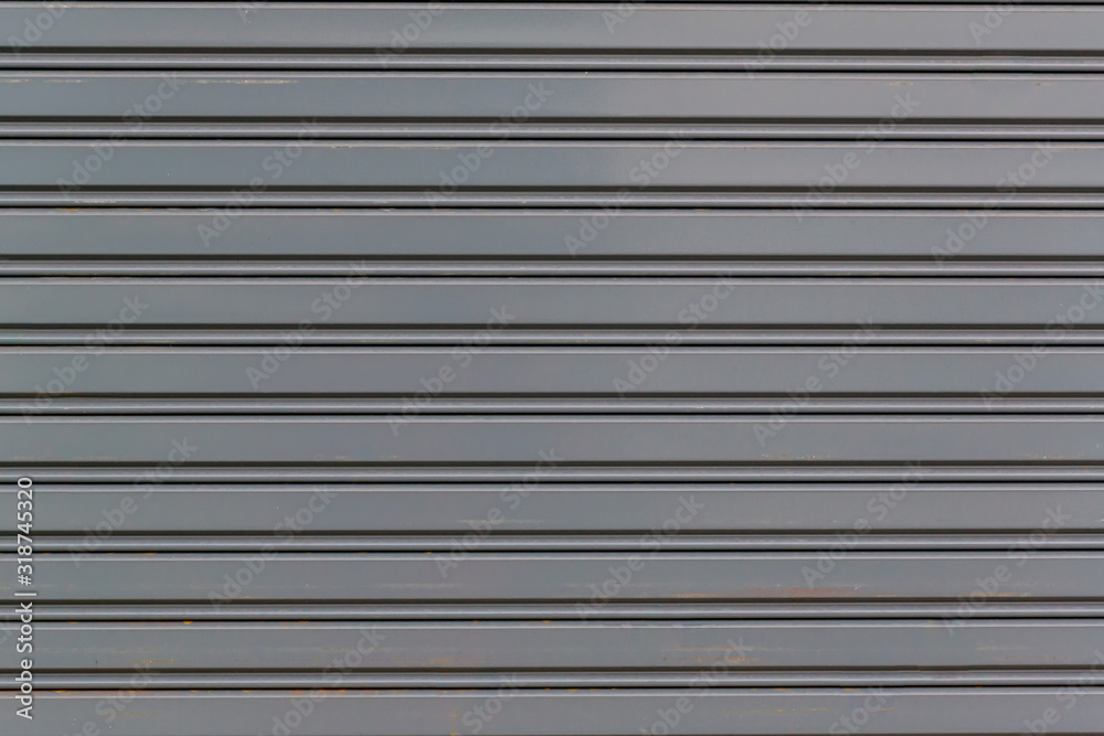 Metallic roll up door. Old Steel rolling shutter background. Metal security shutters protecting a small shop. Metallic roll up door. Old Steel rolling shutter background. Metal security shutters protecting a small shop.