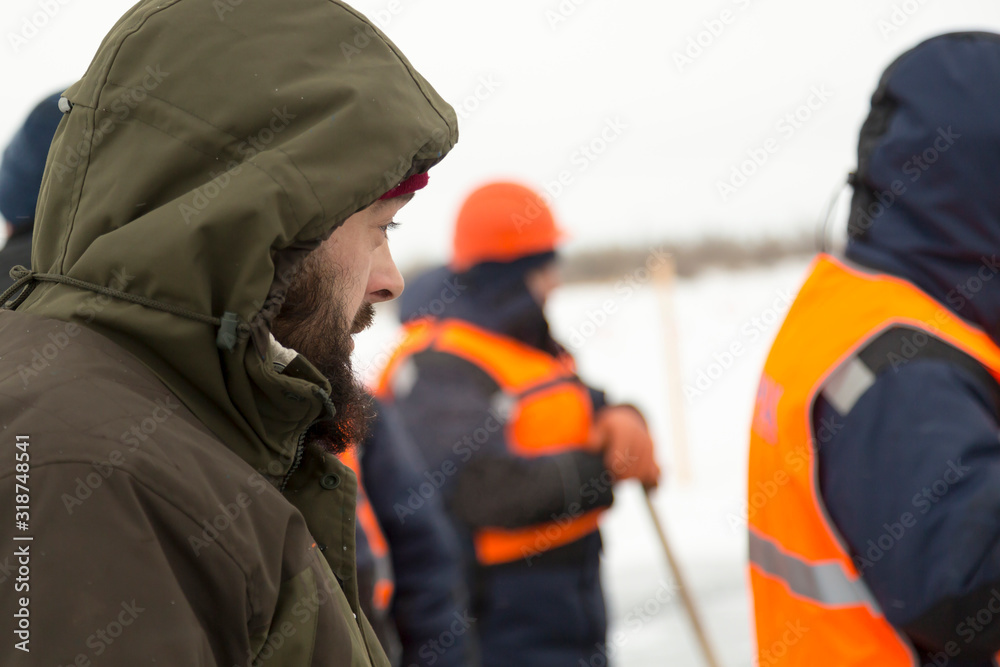 Portrait of a worker in a green jacket with a hood