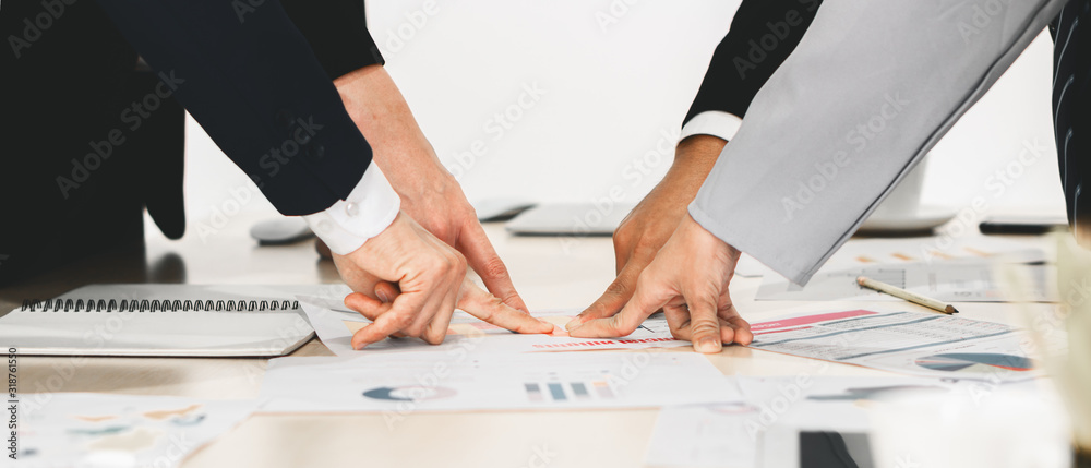hands and fingers of businesspeople pointing at one point on meeting table in concept of aiming together on same business target - obrazy, fototapety, plakaty 