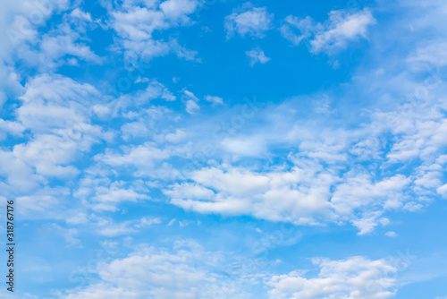 Light cumulus clouds in the blue sky on a sunny day, full frame image, background