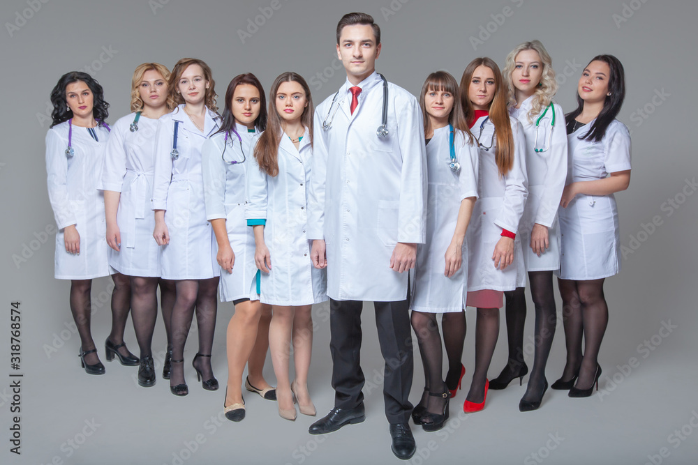 Full length portrait of an attractive male doctor staying at the head of group of doctors