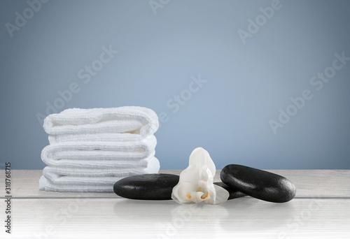 White towels and relax spa stones on desk