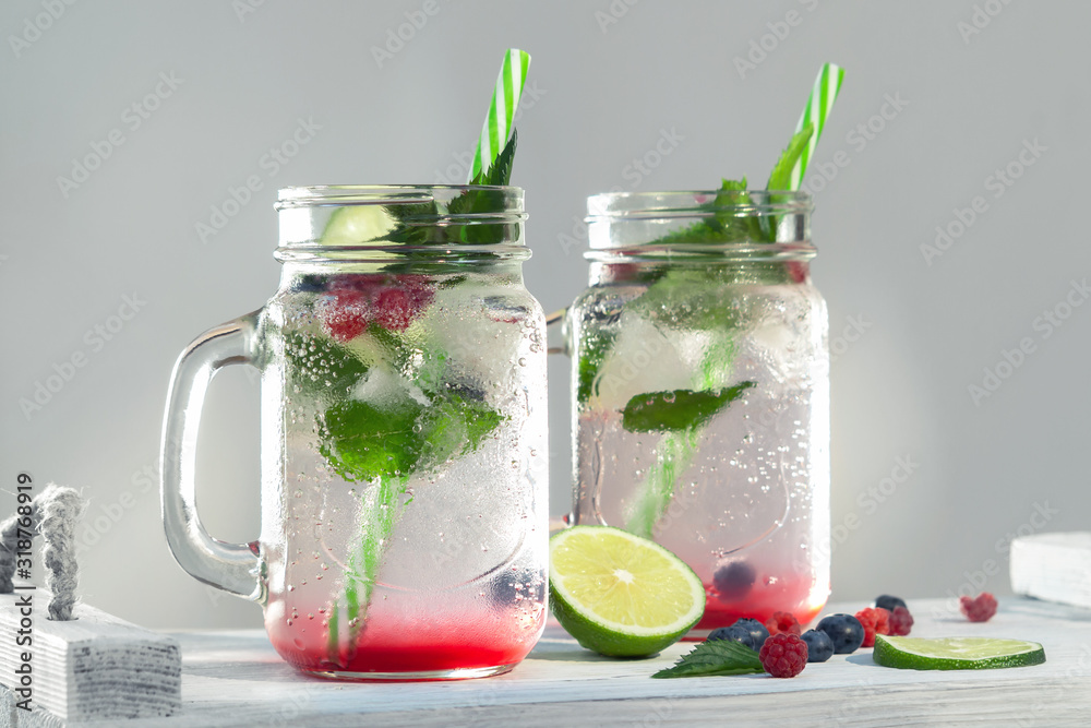 Homemade cold summer cocktail with mineral water, mint, lime, berry juice and fresh berries Homemade cold summer cocktail with mineral water, mint, lime, berry juice and fresh berries