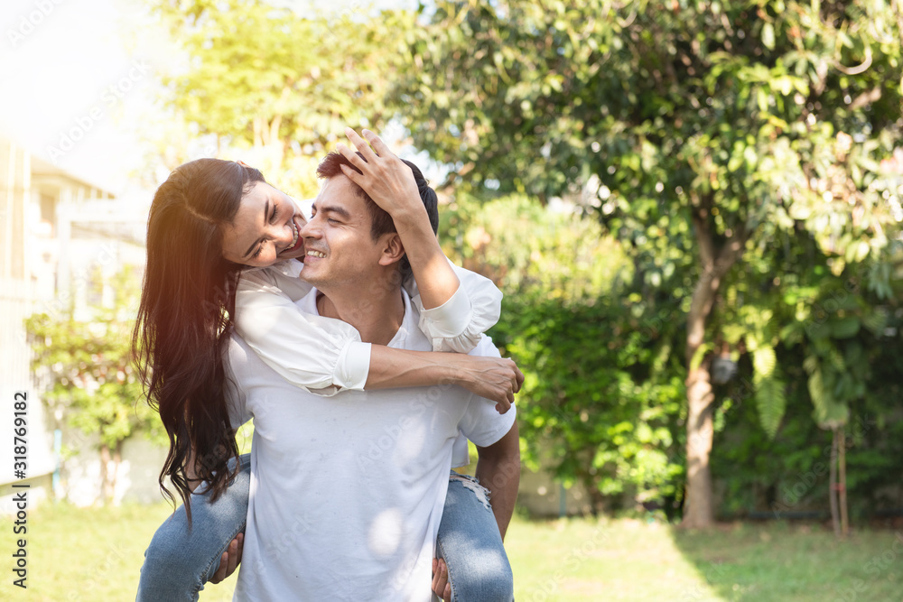 Obraz premium Couple in love asian woman riding on back of caucasian man at park,Romantic and enjoying in moment of happiness time,Happy and smiling,Positive thinking