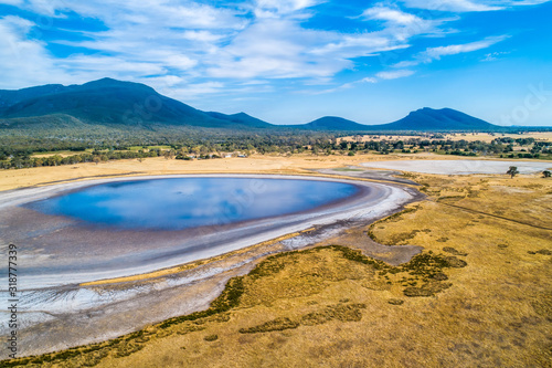 Aerial view of clouds reflecting in a small lake and Grampians mountains in Australia