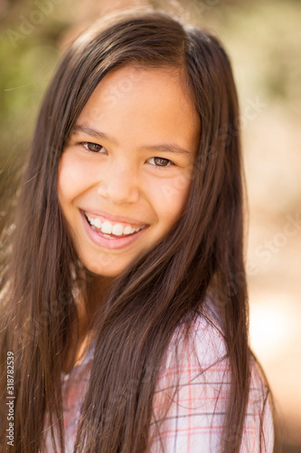 Portrait of a young asian girl smiling outside.