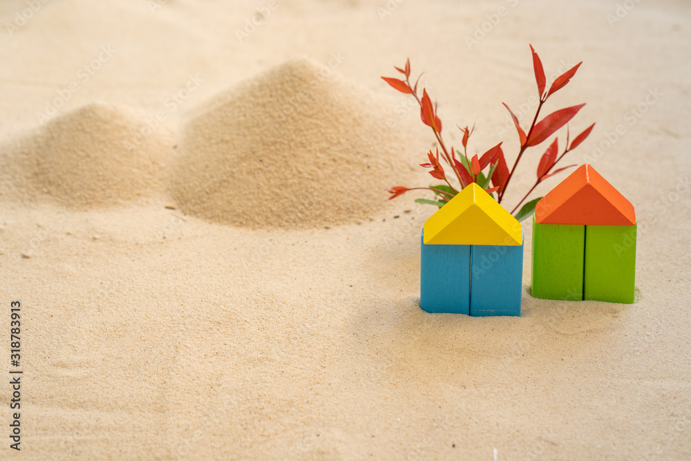 Naklejka premium concept of colored wooden houses on the sand.