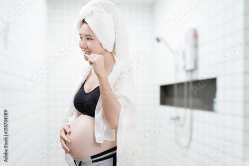 Asian pregnant women brush their teeth in the bathroom.