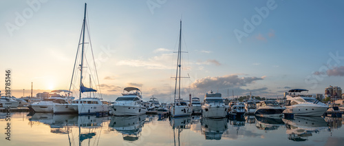 Beautiful clear sunset in the sea harbor with moored yachts. © Dmitrii Potashkin