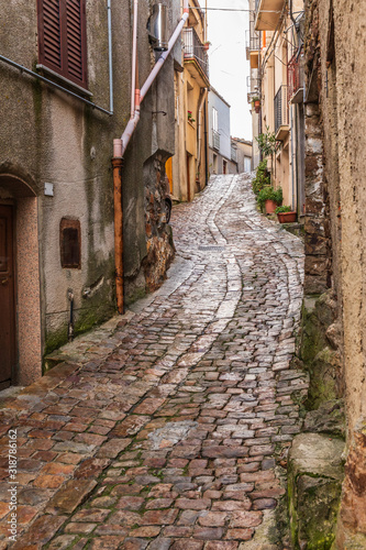 Fototapeta Naklejka Na Ścianę i Meble -  Italy, Sicily, Palermo Province, Geraci Siculo. Winding narrow cobblestone street in the town of Geraci Siculo.