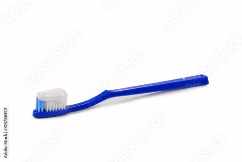 Blue toothbrush with toothpaste in her hand isolated on white background.