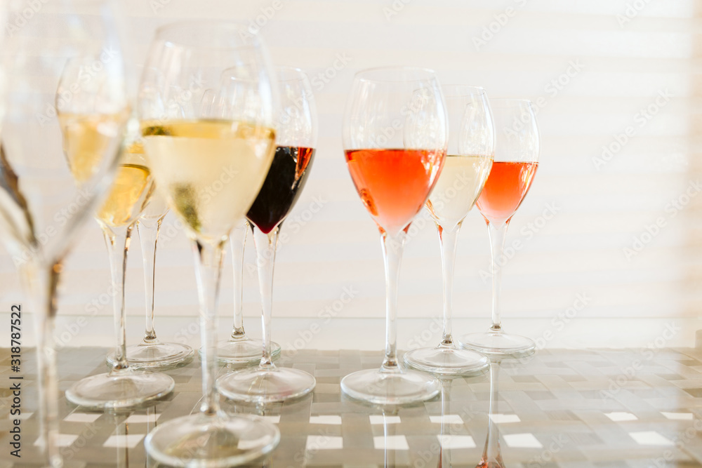 Wine tasting set in the light airy environment. Custom wine tasting concept. Glasses of wine and bottles on the glass table and light background. Wine tasting set in the light airy environment. Custom wine tasting concept. Glasses of wine and bottles on the glass table and light background.