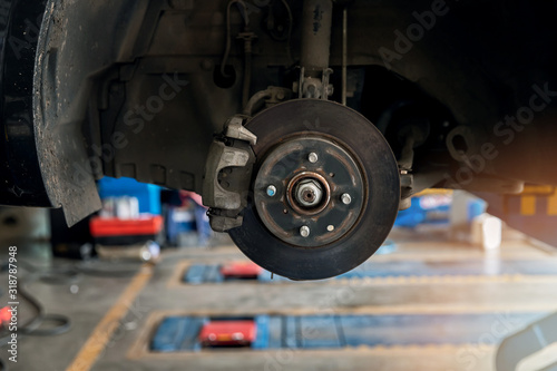 Maintaining car disc brake in process of new tire replacement at repair service station.