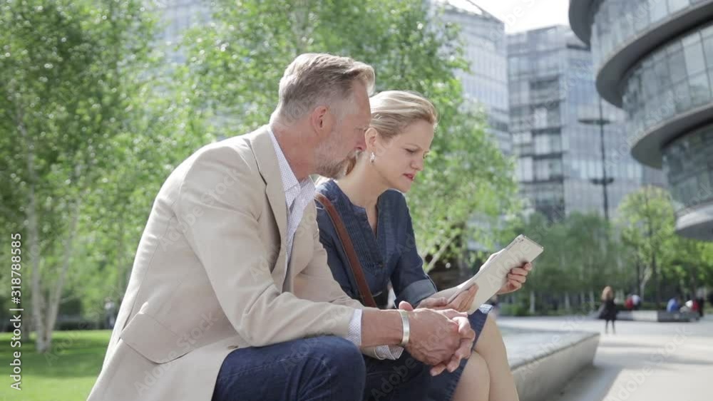 Two colleagues having informal meeting in front of office building Two colleagues having informal meeting in front of office building