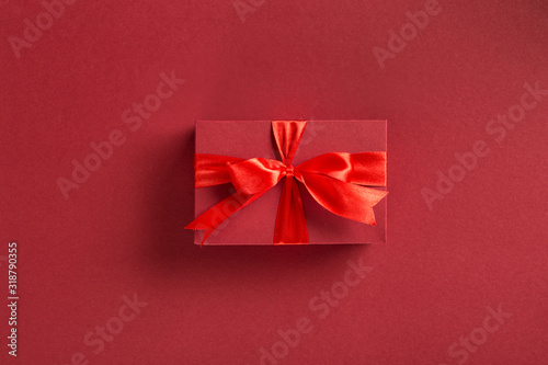 Valentines day or mothers day Red gift box with bow on red background top view