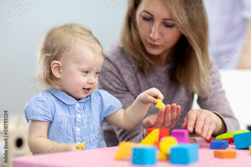 mother and kid daughter playing logical toys at home