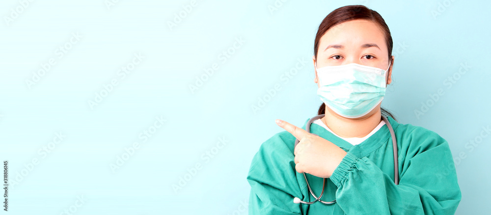 Female asia surgeon,surgeon showing stethoscope wearing surgeon mask, on a blue background in studio With copy space. Female asia surgeon,surgeon showing stethoscope wearing surgeon mask, on a blue background in studio With copy space.
