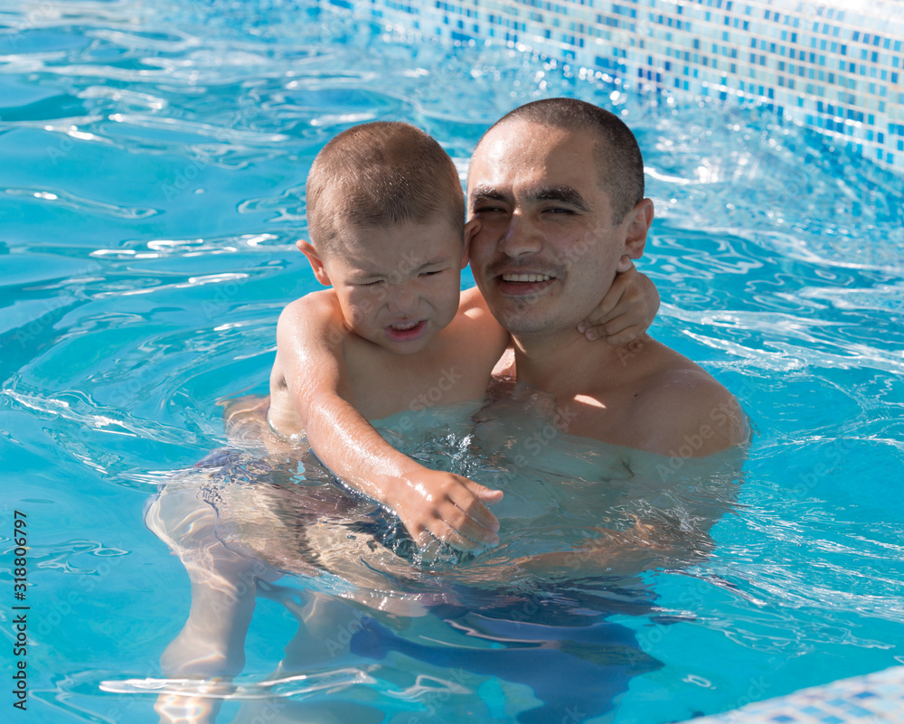 In summer, dad and son play in the water. Summer holidays